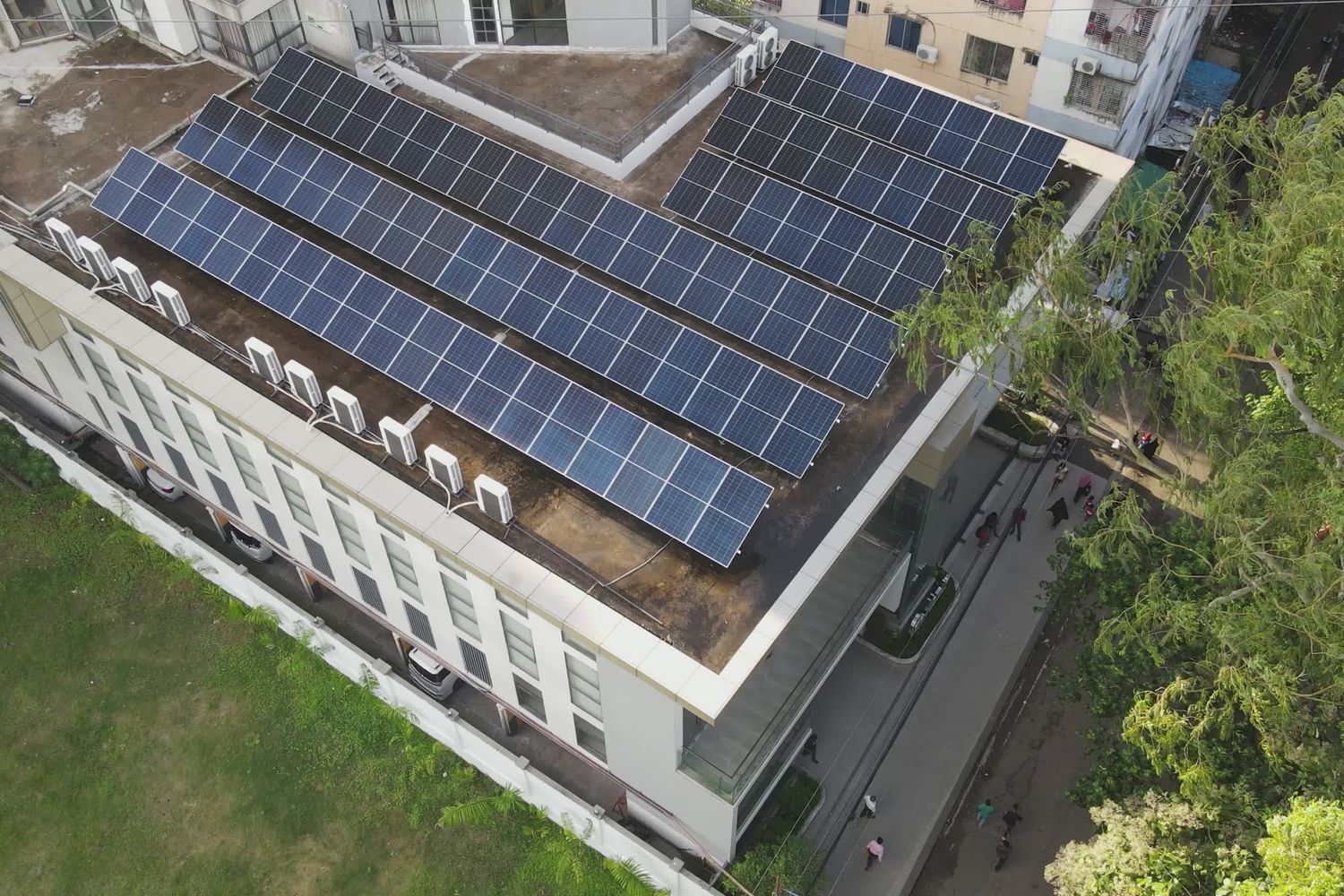 Rooftop solar panels arranged in rows on top of a multi-story building.